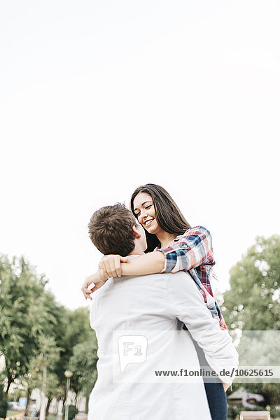 Young couple in love hugging in a park