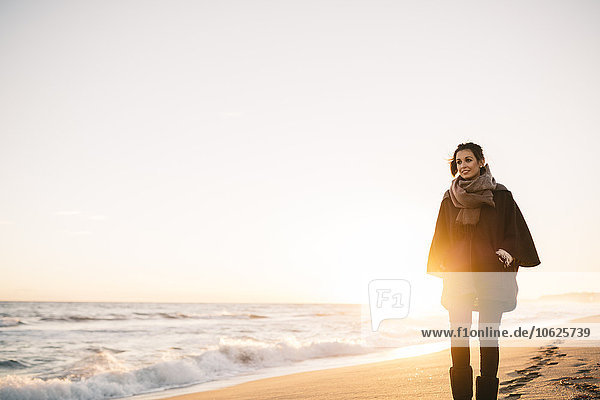 Junge Frau beim Spaziergang am Strand im Winter