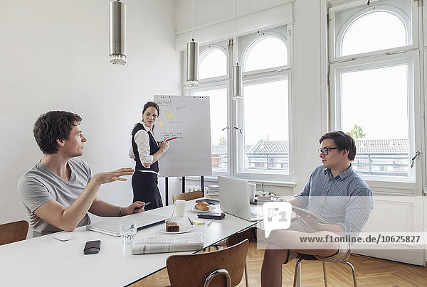 Three creative business people having a meeting in a modern office