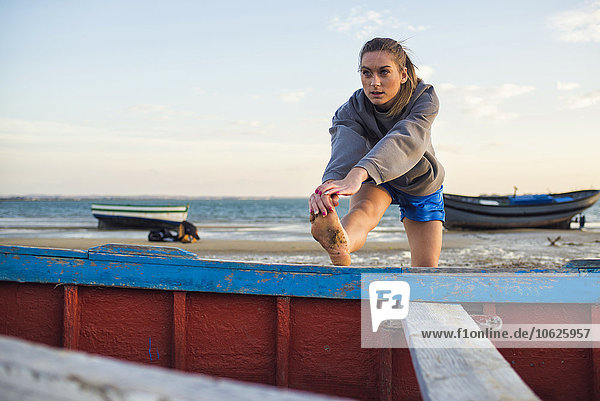 Spanien  Puerto Real  junge Frau beim Stretching am Strand