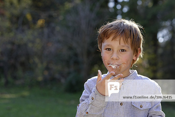 Porträt eines glücklichen Jungen  der Süßigkeiten isst