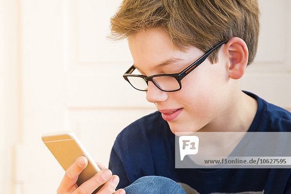 Portrait of smiling boy looking at his smartphone