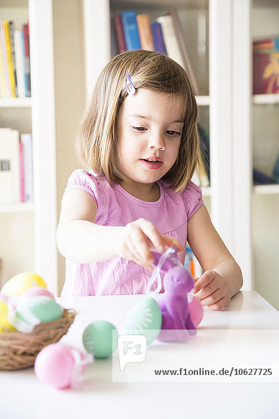 Little girl playing with Easter eggs and Easter bunny