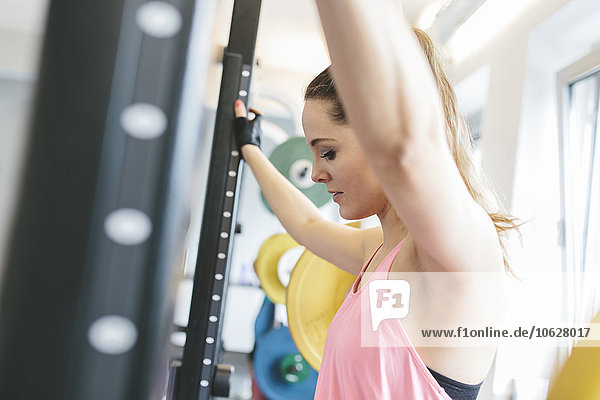 Woman leaning in a power rack looking down