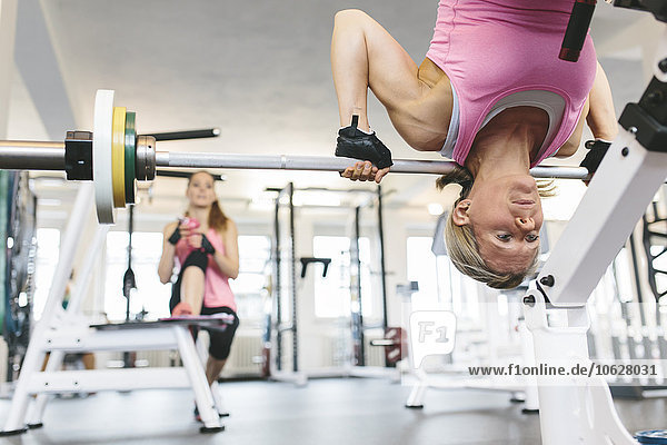 Frau macht gewichtete Rückenverlängerungen im Fitnessstudio
