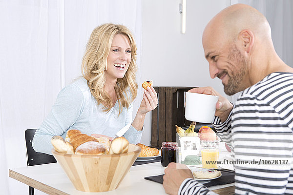 Happy couple having breakfast at hoome