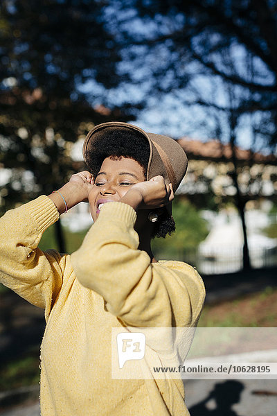 Schöne schwarze Frau mit Hut im Herbst im Freien