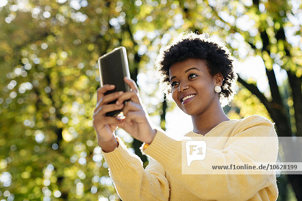 Beautiful black woman with smartphone  outdoor in autumn