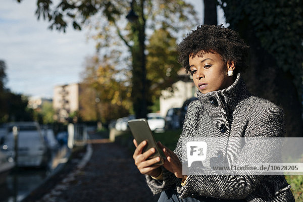 Schöne schwarze Frau mit Smartphone  Outdoor im Herbst