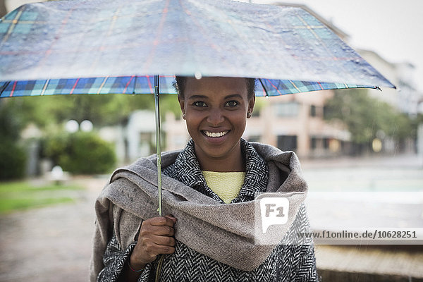 Italien Grado Porträt einer lächelnden Frau mit Regenschirm an einem regnerischen Tag
