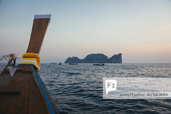 Thailand  Phi Phi Phi Island  Longtailboot bei Sonnenuntergang