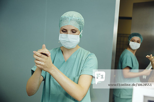 Chirurgin desinfiziert ihre Hände vor der Operation