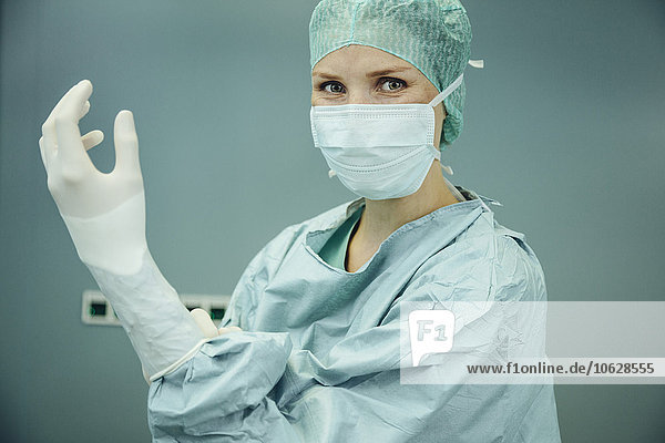 Chirurgin beim Anziehen von Operationshandschuhen