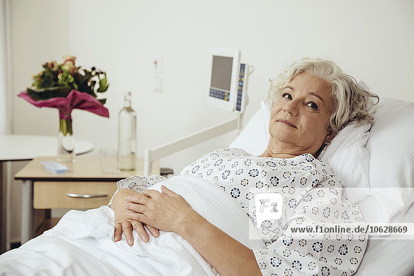 Seniorenfrau im Krankenhaus liegend  sieht besorgt aus