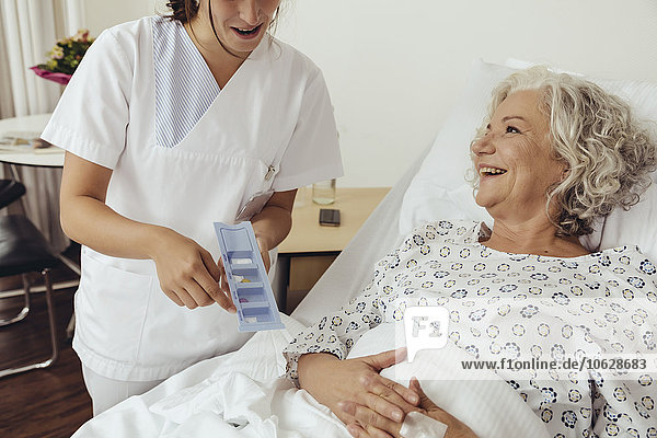 Krankenschwester erklärt ältere Frau im Krankenhaus Medikamente