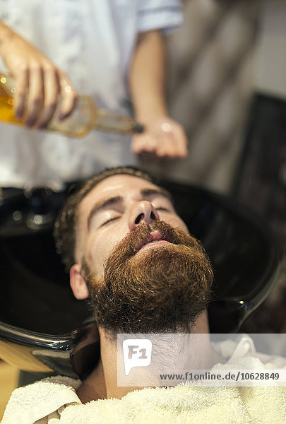 Friseur beim Haarewaschen eines Kunden