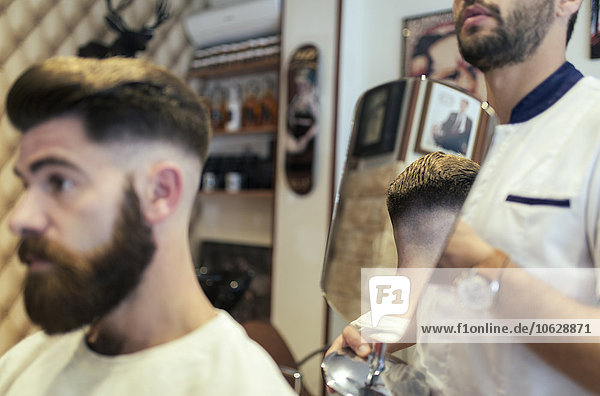 Customer checking his hairstyle in a barber shop