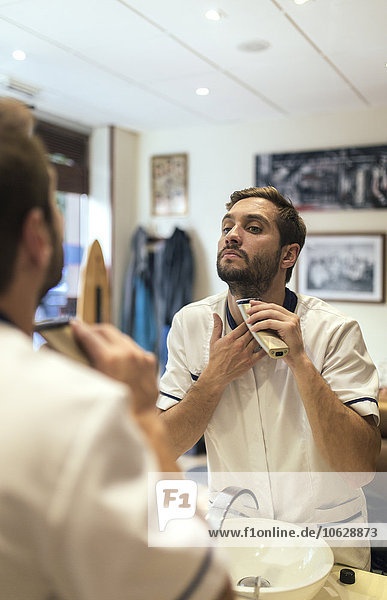 Barber shaving his beard in a barber shop
