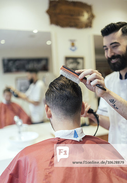 Barber brushing hair of a customer