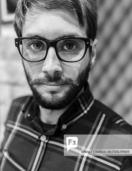 Porträt eines Mannes mit Bartbrille und kariertem Hemd