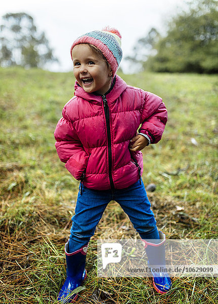 Porträt eines lachenden kleinen Mädchens auf einer Wiese im Herbst