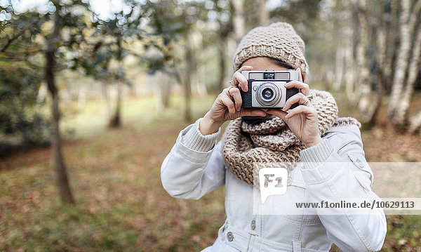 Woman taking a picture in the forest
