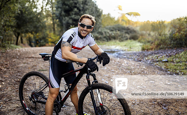 Portrait of smiling mountain biker driving in nature