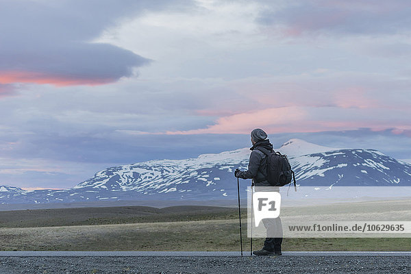 Iceland  Man standing on road looking at volcanos