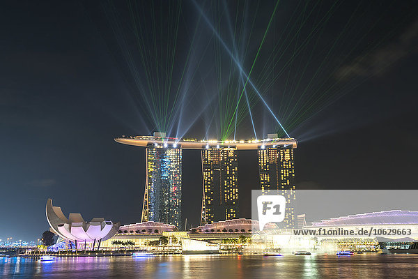 Singapur  Blick auf das Marina Bay Sands Hotel mit Lasershow am Himmel am Abend