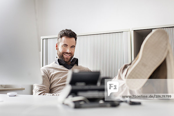 Man in office laying his feet on desk