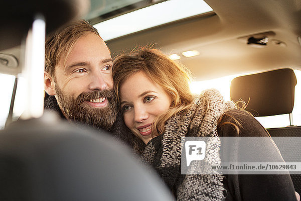 Glückliches Paar beim Kuscheln im Auto