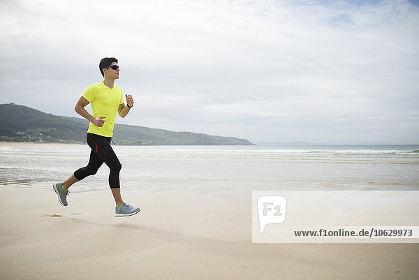 Spain  Ferrol  young man jogging on the beach