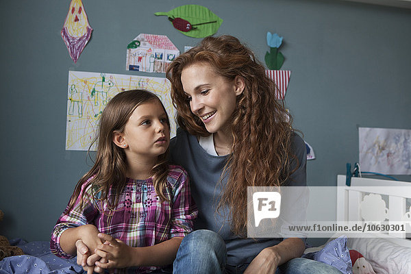Porträt einer Frau mit ihrer kleinen Tochter im Kinderzimmer