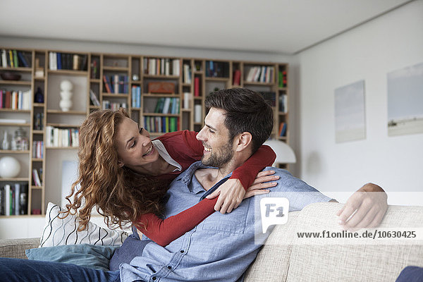 Happy woman hugging man on couch