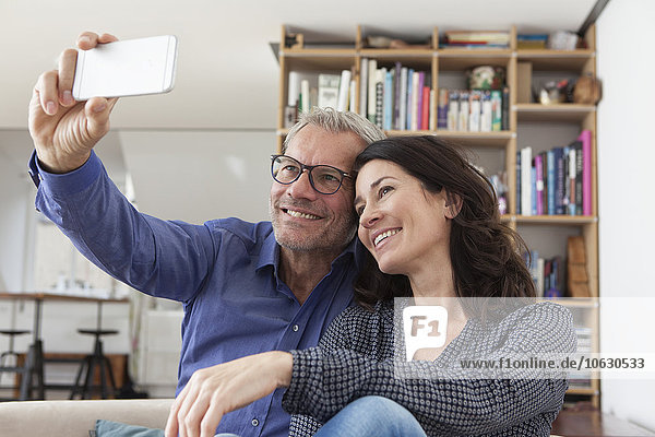 Smiling couple at home taking a selfie