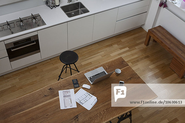 Bauplan  Laptop  Taschenrechner und Handy auf dem Küchentisch