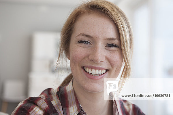 Porträt einer glücklichen jungen Frau mit Sommersprossen