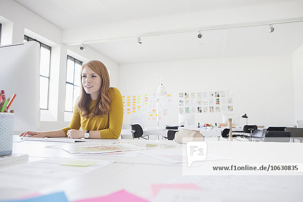Junge Frau im Büro arbeitet am Schreibtisch
