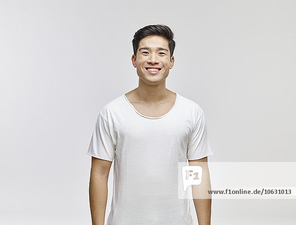 Porträt eines lächelnden jungen Mannes im weißen T-Shirt
