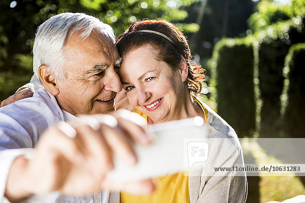 Happy elderly couple taking a selfie outdoors
