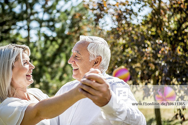 Happy elderly couple dancing outdoors