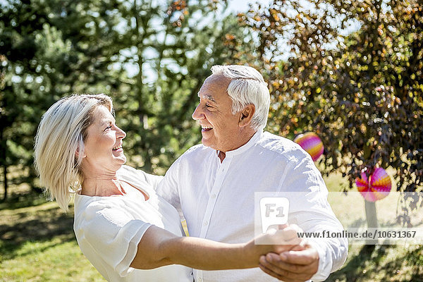 Happy elderly couple dancing outdoors