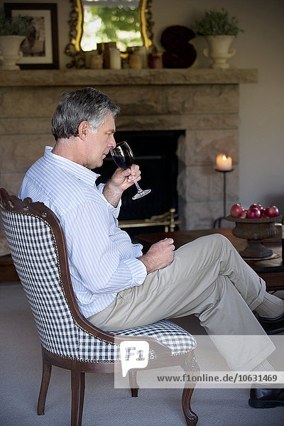 Man with glass of red wine sitting in the living room