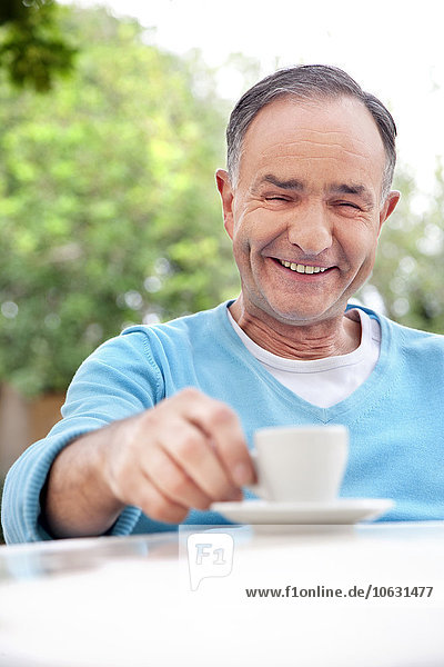 Portrait of smiling mature man sitting with cup of coffee