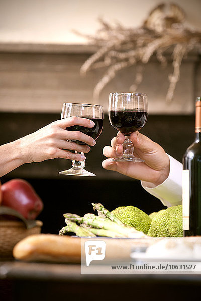 Hands of couple toasting with red wine