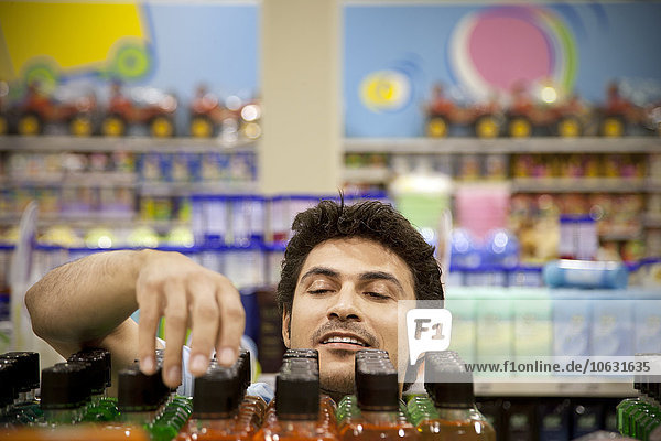 Porträt eines Mannes,  der ein Produkt im Supermarkt sucht