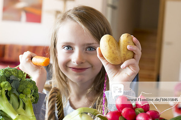 Porträt eines lächelnden Mädchens mit frischem Gemüse