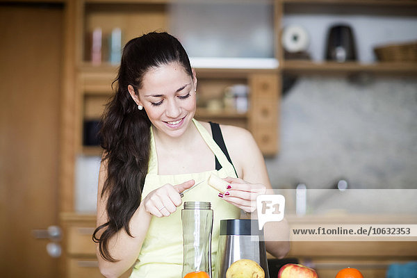 Smiling woman preparing food in her kitchen