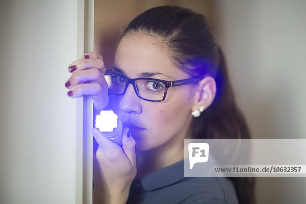 Portrait of woman shining with LED torch