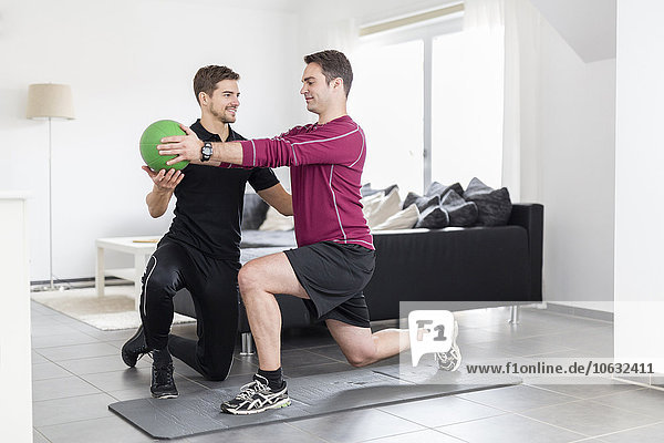 Coach doing exercises with man at home